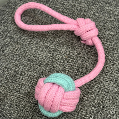 Pink and mint green rope dog toy with knot and loop on gray fabric background
