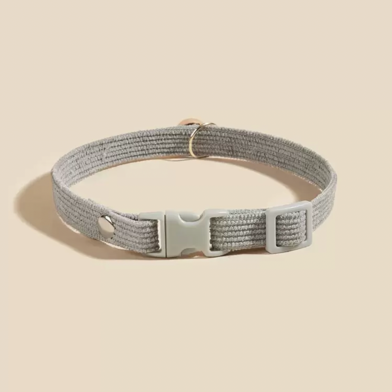 Gray adjustable pet collar with plastic buckle and metal ring on beige background