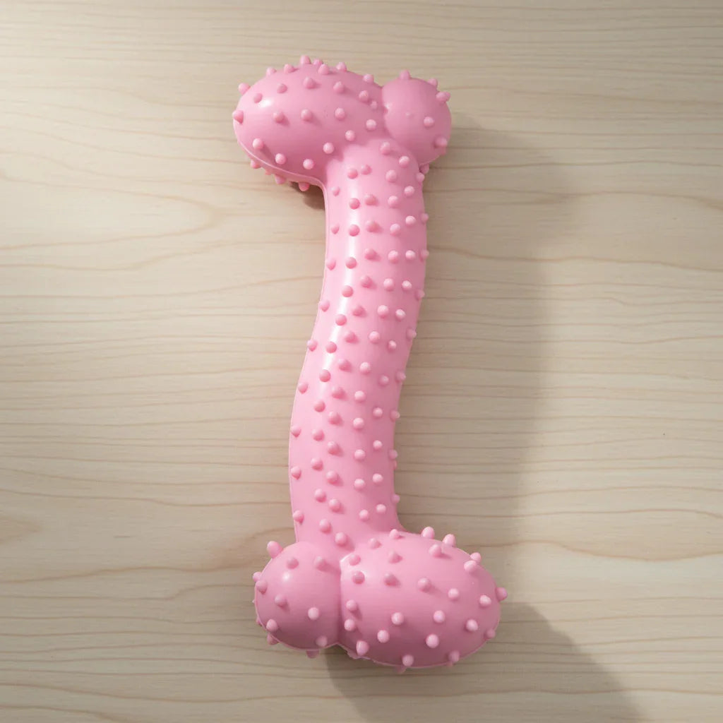 Pink textured bone-shaped dog chew toy on light wood surface