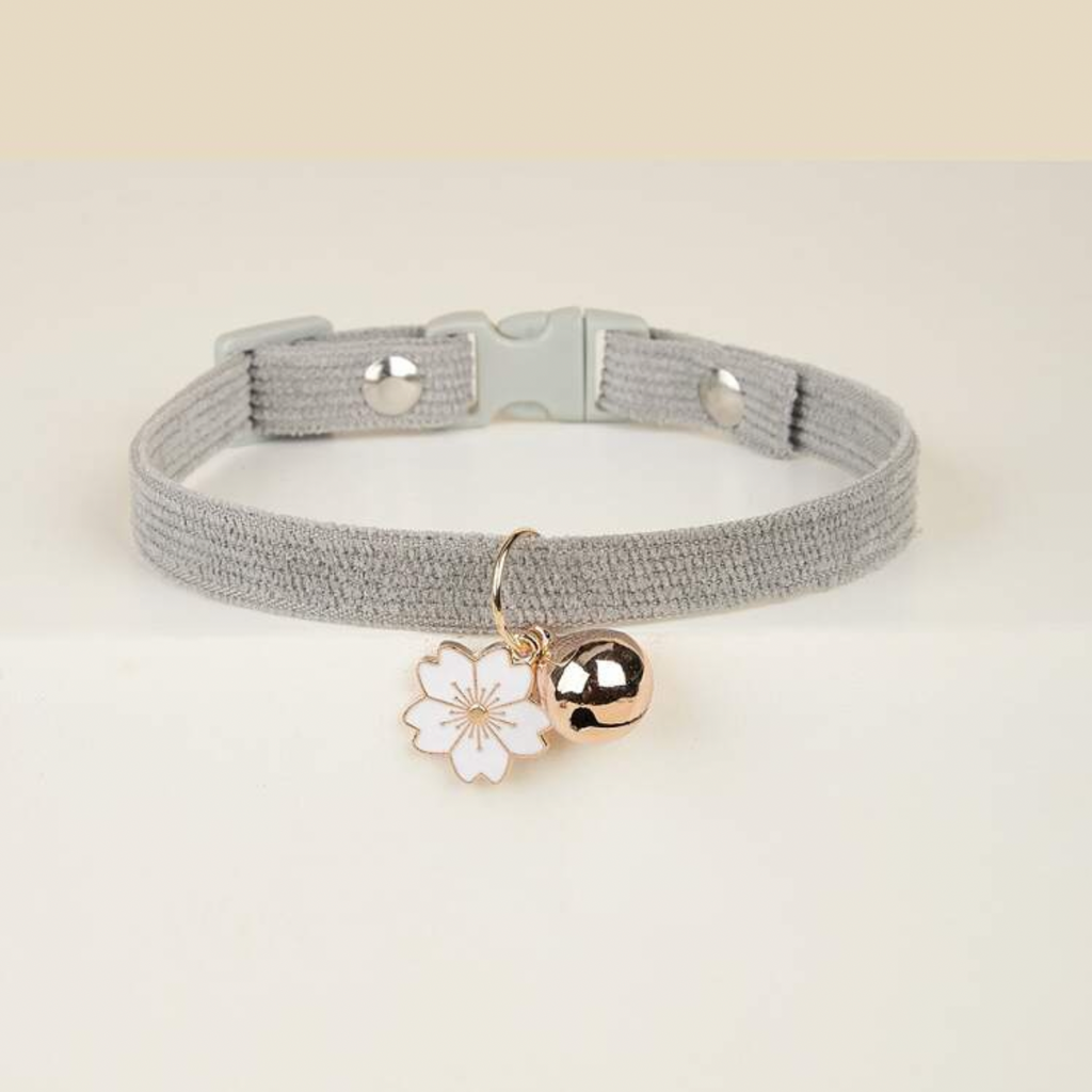 Gray pet collar with cherry blossom charm and gold bell on white background