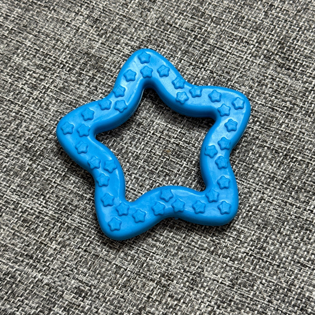 Blue star-shaped textured dog chew toy on a grey fabric background