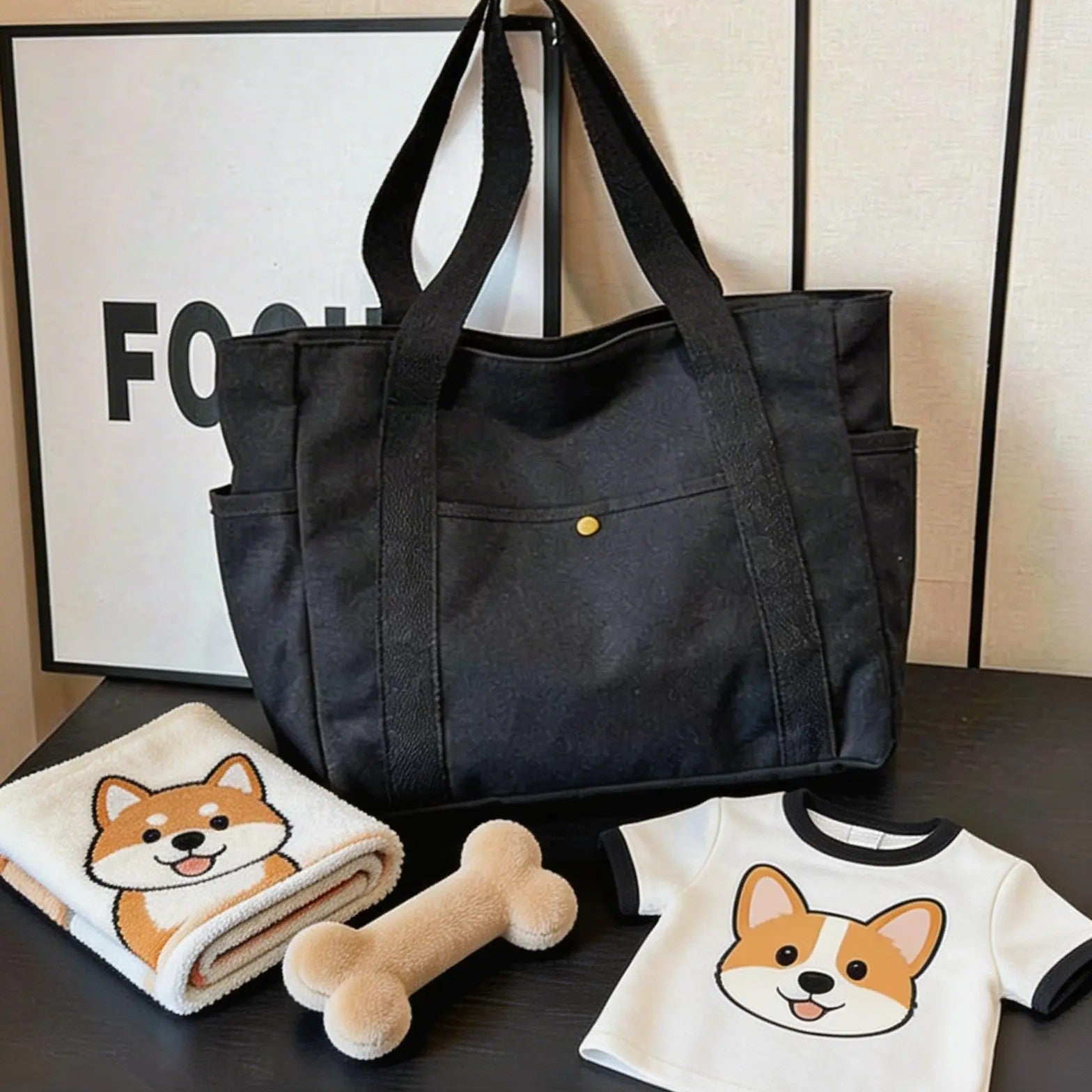 Black pet carrier bag with dog-print shirt, plush bone toy, and cartoon dog towel