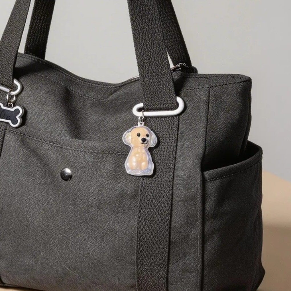 Black tote bag with a cute dog keychain and dog bone charm on the strap