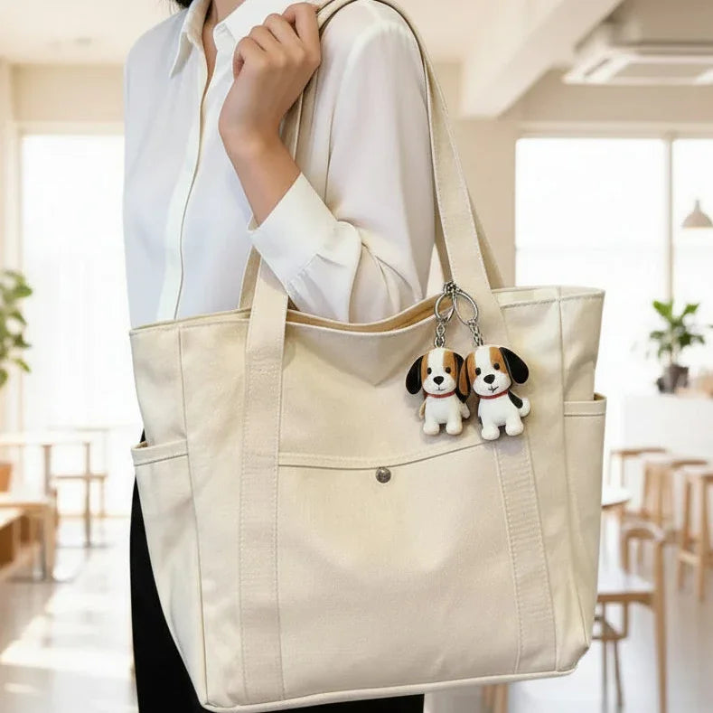 Woman holding cream tote bag with cute beagle dog keychain accessories in a modern room
