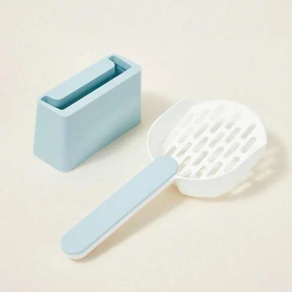 Blue and white plastic cat litter scoop with matching holder on a beige background