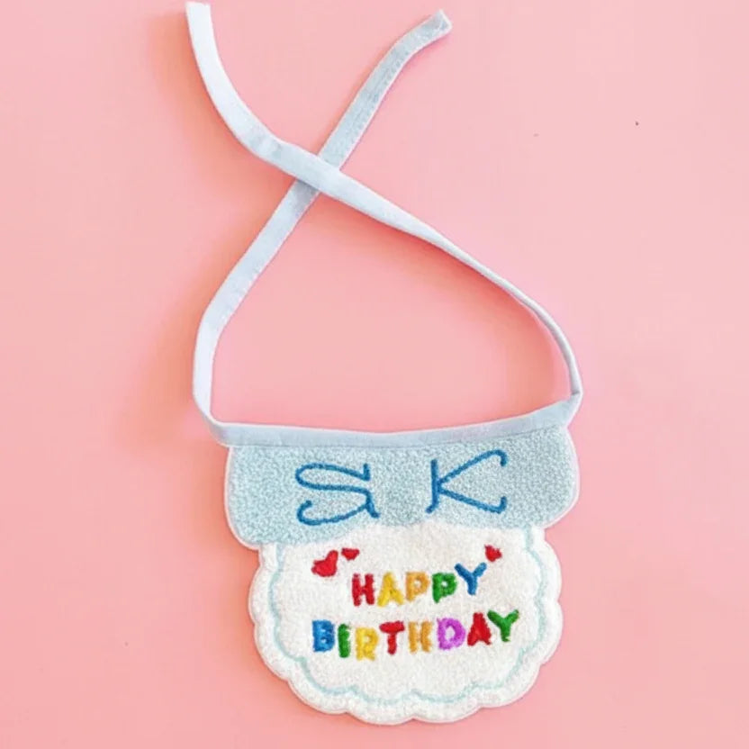 Colorful pet birthday bandana with embroidered 'Happy Birthday' text on pink background