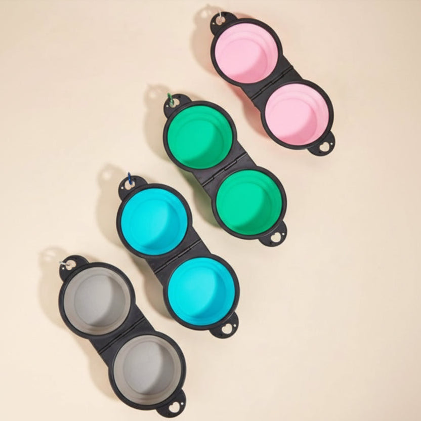 Collapsible silicone pet bowls in pink, green, blue, and gray on a beige background