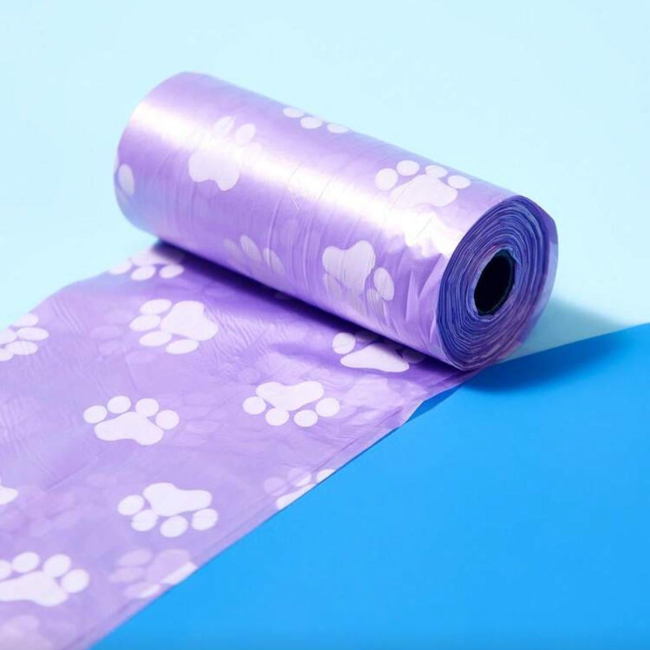 Purple pet waste bag roll with white paw prints on a blue background