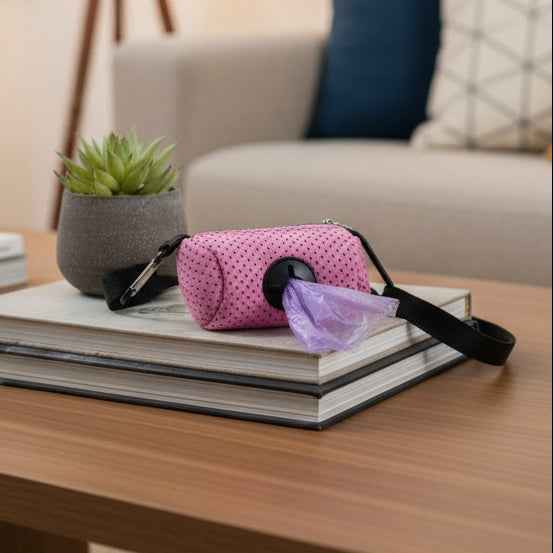 Pink dog waste bag dispenser with strap on coffee table, living room background