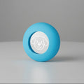 Blue round pet toy with a white dog face design, placed on a neutral background