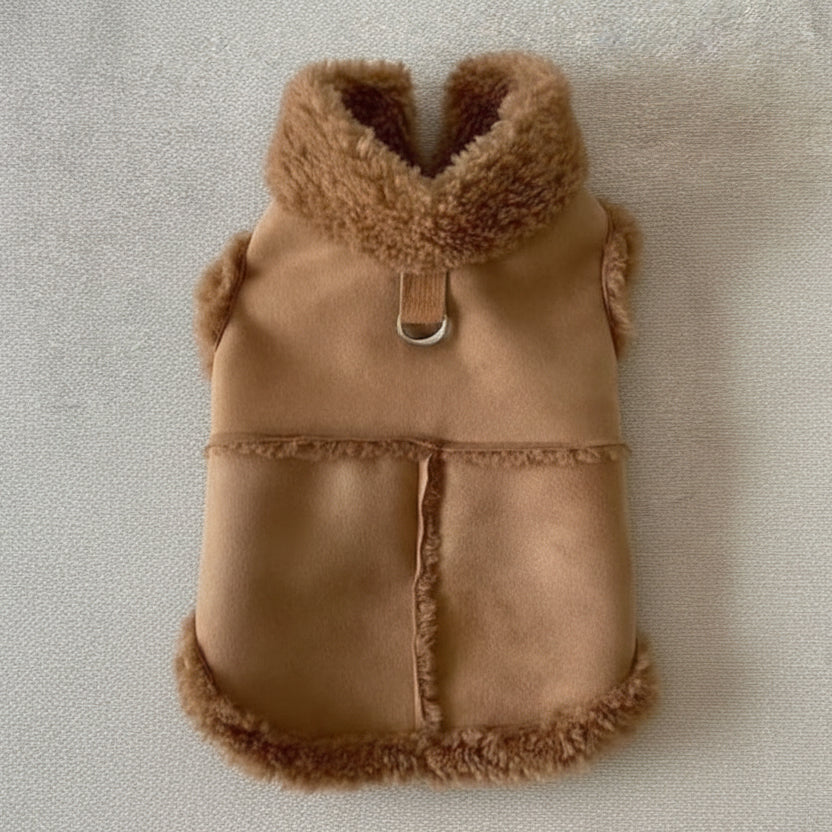 Brown fleece-lined dog coat with faux fur trim and D-ring on a beige surface